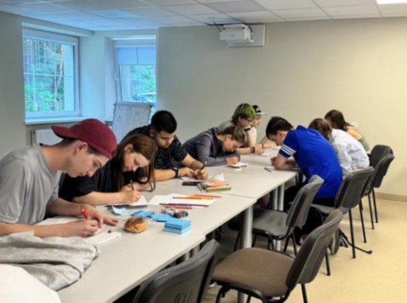young people sitting and working around the table